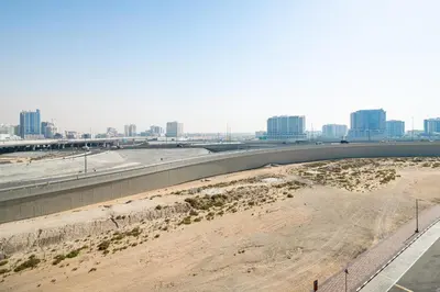 an empty freeway with a city in the background at Stylish Studio Apartment in Binghatti Crystals in Dubai