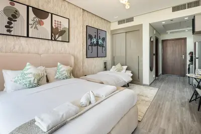 two beds in a hotel room with two beds at Stylish Studio Apartment in Binghatti Crystals in Dubai