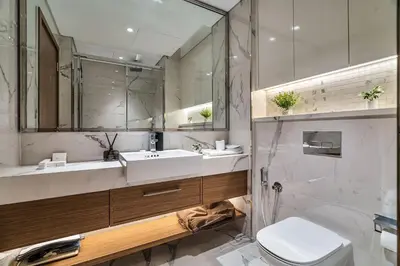 a bathroom with a sink and a toilet and a mirror at Elegant 1-Bed with Pool, Gym, Parking and Balcony in Dubai