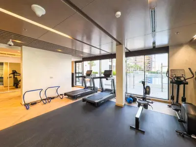 a gym with treadmills and ellipticals in a building at Elegant 1-Bed with Pool, Gym, Parking and Balcony in Dubai