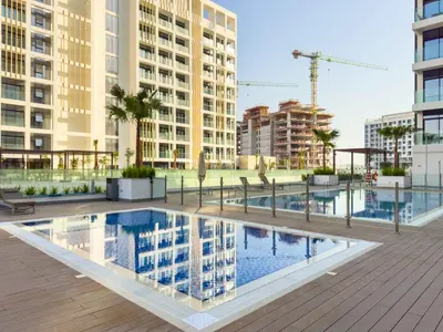 a pool in the middle of a city with buildings at Elegant 1-Bed with Pool, Gym, Parking and Balcony in Dubai