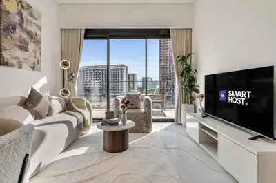 a living room with a couch and a tv at Elegant 1-Bed with Pool, Gym, Parking and Balcony in Dubai