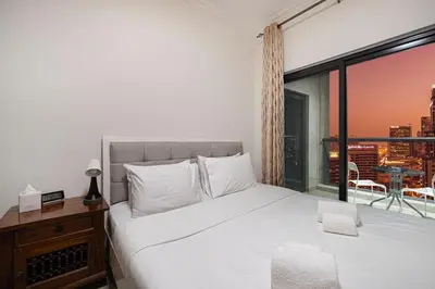 a bedroom with a large bed and a large window at Prime Location - Marina full View - Perfect for holidays in Dubai