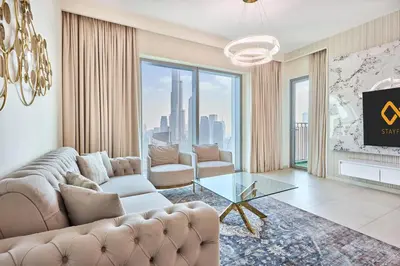 a living room with a couch and a glass table at Luxury 4 Bedroom High-Floor Apartment, Spectacular Burj Khalifa & Fountain Views, Steps Away from Dubai Mall - Downtown Dubai by Stayfinity in Dubai