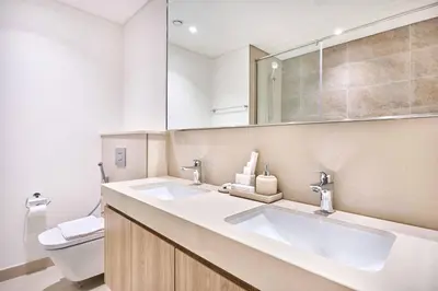 a bathroom with two sinks and a toilet at Luxury 4 Bedroom High-Floor Apartment, Spectacular Burj Khalifa & Fountain Views, Steps Away from Dubai Mall - Downtown Dubai by Stayfinity in Dubai