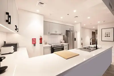 a kitchen with white cabinets and a white counter top at Spacious 4-Bedroom Apartment with Full Fountain and Burj Khalifa Views - 10 min Walk to Dubai Mall in Dubai