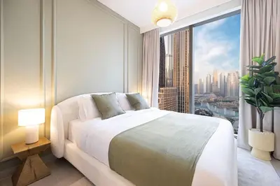 a bedroom with a large bed and a large window at Spacious 4-Bedroom Apartment with Full Fountain and Burj Khalifa Views - 10 min Walk to Dubai Mall in Dubai