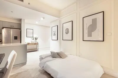 a white bedroom with a bed and a kitchen at Spacious 4-Bedroom Apartment with Full Fountain and Burj Khalifa Views - 10 min Walk to Dubai Mall in Dubai