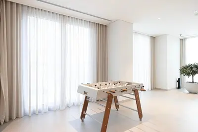 a ping pong table in a room with windows at Spacious 4-Bedroom Apartment with Full Fountain and Burj Khalifa Views - 10 min Walk to Dubai Mall in Dubai