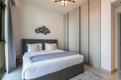 a bedroom with a large bed with white walls at Alluring 1BDR apartment in Dubai Creek Harbour in Dubai