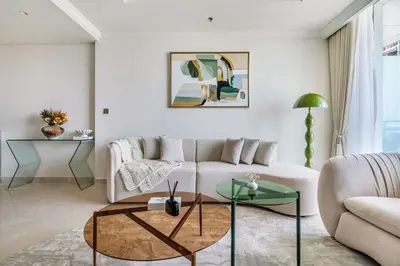 a living room with a white couch and a table at Elegant 1BR Apartment with Private Beach Access! in Dubai