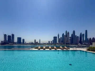 a swimming pool with a city skyline in the background at Elegant 1BR Apartment with Private Beach Access! in Dubai