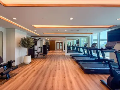 a gym with a row of treadmills and exercise equipment at Elegant 1BR Apartment with Private Beach Access! in Dubai