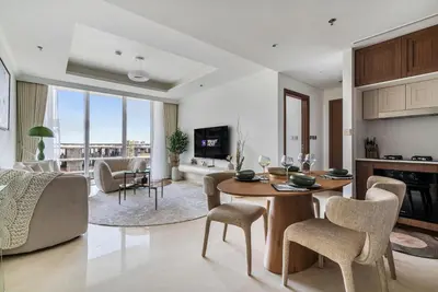 a living room with a table and chairs and a couch at Elegant 1BR Apartment with Private Beach Access! in Dubai