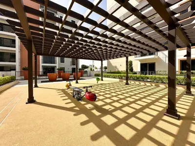 a motor scooter parked under a wooden pergola at Chic 1BR on La Mer Upgraded & Elegant in Dubai
