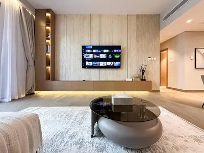a living room with a table and a tv at Chic 1BR on La Mer Upgraded & Elegant in Dubai