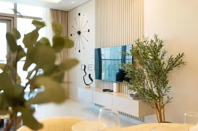 a living room with a clock on the wall at 2BR with Balcony Overlooking City and Burj Khalifa, Minutes Away from Dubai Mall, Paramount Tower Hotel and Residences, Business Bay by Deluxe Holiday Homes in Dubai