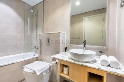 a bathroom with a sink and a toilet and a shower at 2BR with Balcony Overlooking City and Burj Khalifa, Minutes Away from Dubai Mall, Paramount Tower Hotel and Residences, Business Bay by Deluxe Holiday Homes in Dubai