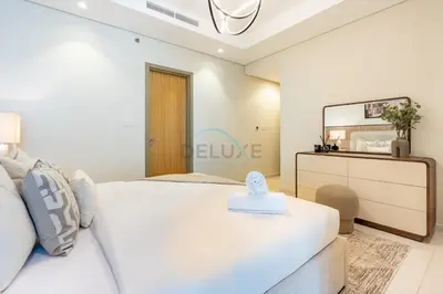 a bedroom with a white bed and a mirror at 2BR with Balcony Overlooking City and Burj Khalifa, Minutes Away from Dubai Mall, Paramount Tower Hotel and Residences, Business Bay by Deluxe Holiday Homes in Dubai