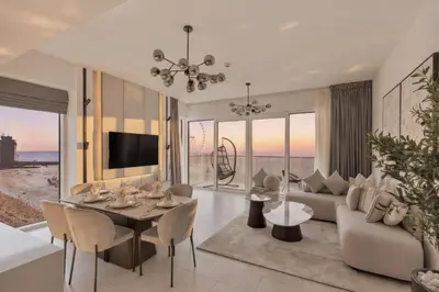 a living room with a couch and a table and chairs at La Vie Jumeirah Beach Residence 3 Bedroom Beachfront Apartment with Palm Views in Dubai