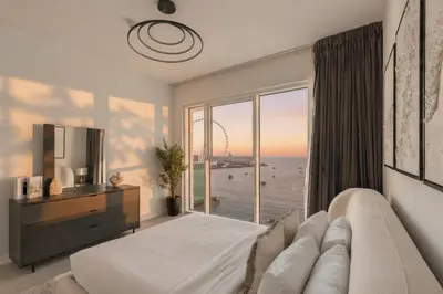 a bedroom with a bed and a view of the ocean at La Vie Jumeirah Beach Residence 3 Bedroom Beachfront Apartment with Palm Views in Dubai