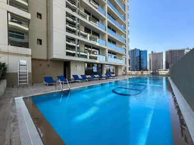 a large swimming pool in the middle of a building at Modern 2BR with Private Terrace, Pool and Gym Access in Dubai