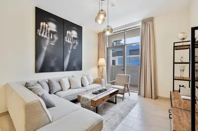 a living room with a couch and a table at Modern 2BR with Private Terrace, Pool and Gym Access in Dubai