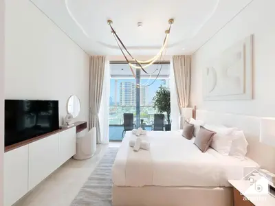 a white bedroom with a large bed and a tv at High End 1BR Palm Beachfront Pool Access in Dubai