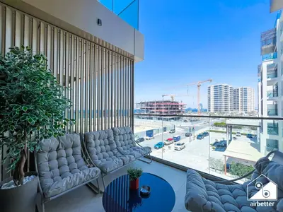 a balcony with couches and a view of a city at High End 1BR Palm Beachfront Pool Access in Dubai