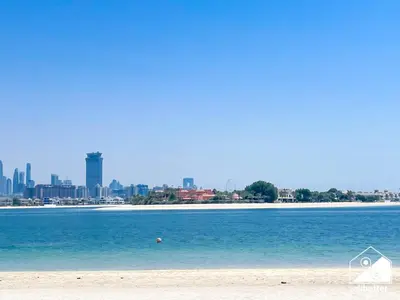 a view of a beach with a city in the background at High End 1BR Palm Beachfront Pool Access in Dubai