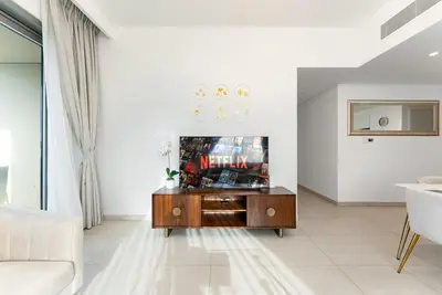 a living room with a tv and a couch at Downtown Views II 2 Bedroom with City Skyline and Sea Views in Dubai