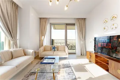 a living room with a couch and a tv at Downtown Views II 2 Bedroom with City Skyline and Sea Views in Dubai