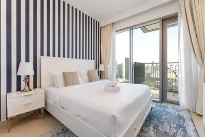 a bedroom with a white bed with a teddy bear on it at Downtown Views II 2 Bedroom with City Skyline and Sea Views in Dubai