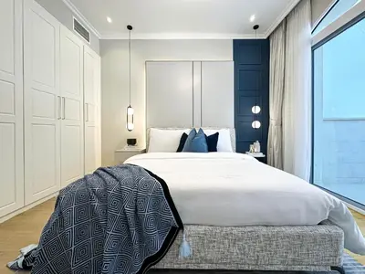 a bedroom with a large bed and a large window at Elegant 2BR Plus Guest Room Stay with Designer Interior in Dubai