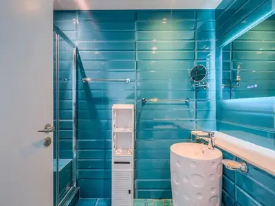 a blue tiled bathroom with a sink and a shower at TRPS - Marina Heights Tower, Dubai Marina - 2BR Upgraded Apartment - with Stunning Marina Skyline in Dubai