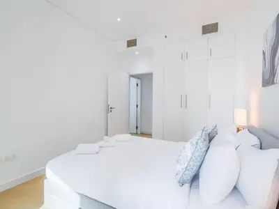 a white bedroom with a white bed and pillows at TRPS - Marina Heights Tower, Dubai Marina - 2BR Upgraded Apartment - with Stunning Marina Skyline in Dubai