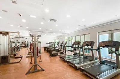 a gym with a row of treadmills and ellipticals at 2 Bedroom Apartment BLVD Central 1 with Boulevard Views in Dubai