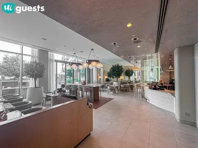 a lobby of a restaurant with tables and chairs at HiGuests - Wake up to Burj Khalifa views in stunning 2 BR in Dubai