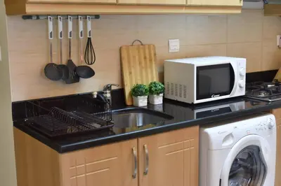 a kitchen with a sink and a microwave at Relaxing and luxurious studio-Dubai in Dubai