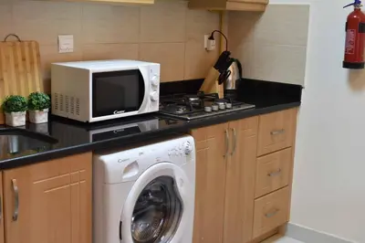 a kitchen with a washing machine and a microwave at Relaxing and luxurious studio-Dubai in Dubai