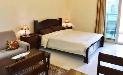 a bedroom with a large bed and a couch at Relaxing and luxurious studio-Dubai in Dubai