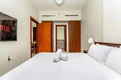 a bedroom with a white bed with a towel on it at Business Bay 2 Bedroom with Burj Khalifa Views in Dubai