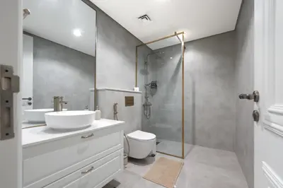 a bathroom with a sink and a toilet and a shower at Stylish JVC 2BR Stay with Guest Room Rose Gold Accents in Dubai