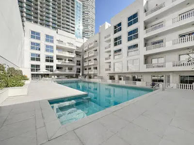 a swimming pool in front of a building at Stylish JVC 2BR Stay with Guest Room Rose Gold Accents in Dubai