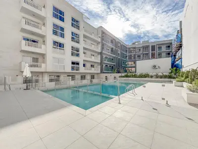 an apartment building with a swimming pool in a courtyard at Stylish JVC 2BR Stay with Guest Room Rose Gold Accents in Dubai