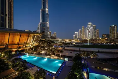 a view of a city at night with a swimming pool at Seraya at Grande Signature Residences in Dubai