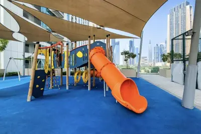 a playground with an orange slide in a building at Burj Khalifa Views at Downtown Views II 3 Bedroom Apartment in Dubai