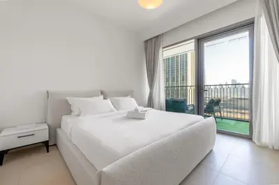 a bedroom with a large white bed and a large window at Burj Khalifa Views at Downtown Views II 3 Bedroom Apartment in Dubai