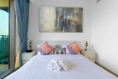 a bedroom with a white bed with two towels at Downtown Views II 2 Bedroom Apartment Next to Dubai Mall in Dubai