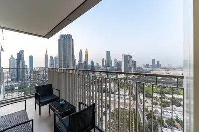 a balcony with chairs and a view of the city at Stunning Corner 2 Bedroom in Downtown Views II in Dubai